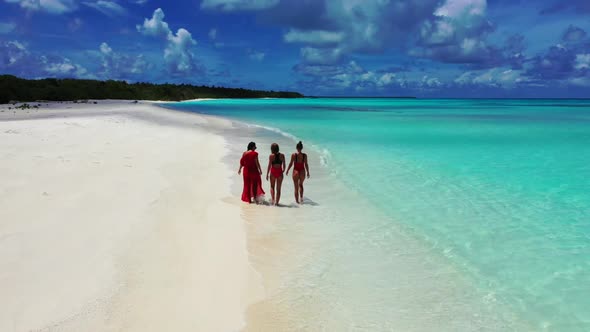 Girls happy together on relaxing resort beach lifestyle by turquoise water and white sand background