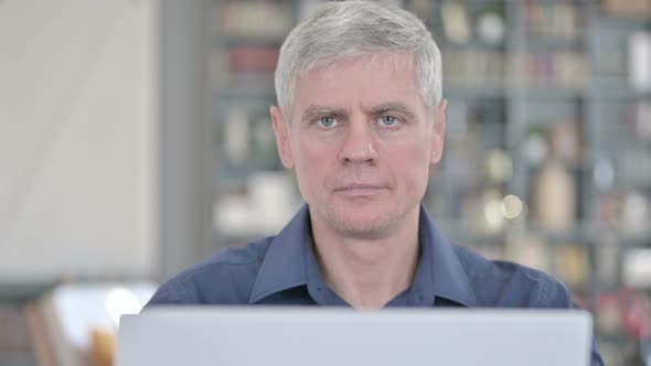 Portrait of Middle Aged Man Looking at Camera and Smiling