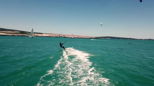 professional watersports kite-surfer doing a kiteloop jump trick during beautiful natural daylight w