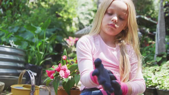 Little girl putting gloves before gardening