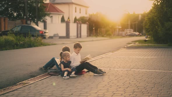 Nervous Schoolboy Throws Textbook on Grey Asphalt Road