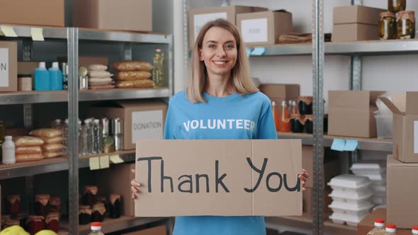 Positive Volunteer Showing Banner with Phrase Thank you