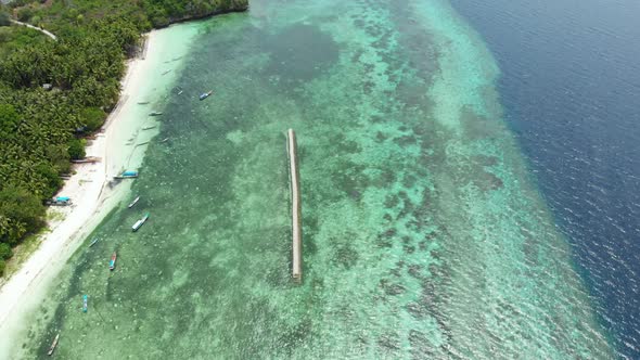 Aerial: Flying over tropical beach turquoise water coral reef , Tomia island Wak