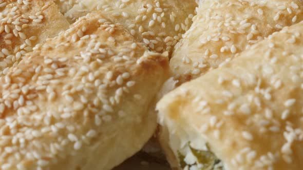 Tasty dough rolls baked with filling close-up 4K 2160p 30fps UHD tilting footage - Filo pie with ses