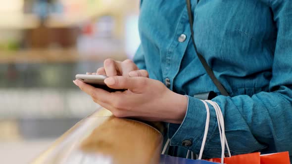 Woman using mobile phone during shopping