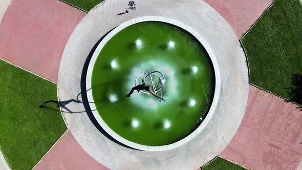 View of unusual round fountain with bright green water in golden evening light