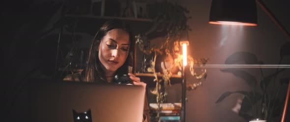 Woman examines camera while at desk