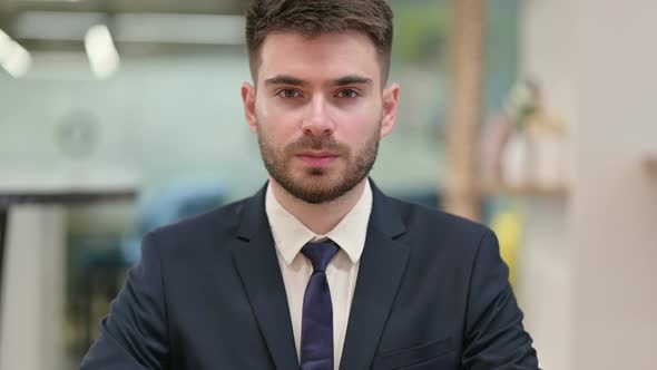 Serious Young Businessman Looking at Camera 