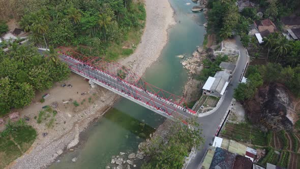 Beautiful aerial view of a bridge over a river nestled between mountains