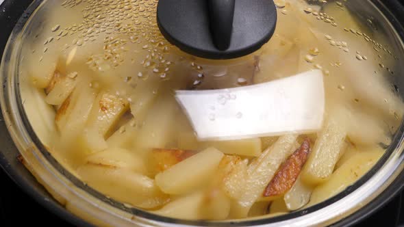 Open and Close Cap of Pan. Cooking Fried Potato on Frying Pan. Roasting Sliced Potatoes