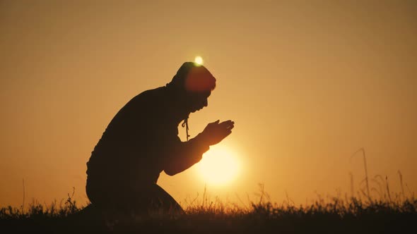Silhouette Young Man Praying Outside at Beautiful Sunset alt