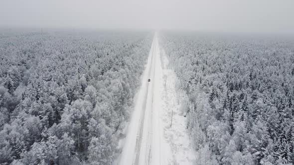 Aerial Top View From Drone Birds Eye View of Winter Landscape and Snowy Ice Road Car Moving on Area