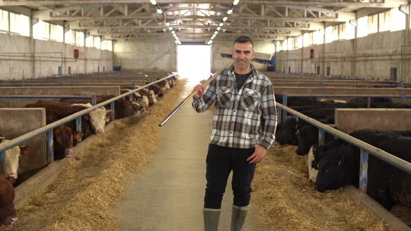 Happy farmer at meat fattening farm looking at camera.