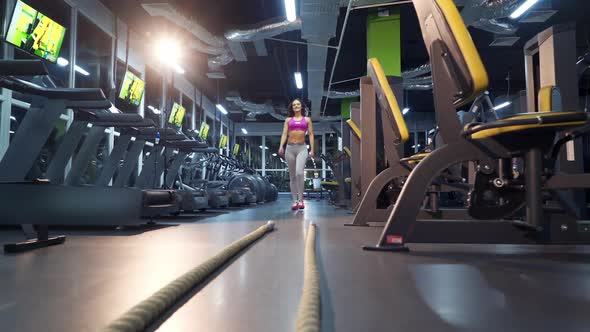 Young woman exercising using skipping rope in gym. Athletic woman training hard at the gym.