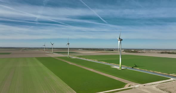 Dutch landscape with typical wind turbines and a water canal.