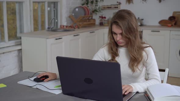 Young Woman with Laptop Works at Home