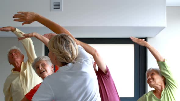 Trainer assisting senior citizens in exercising