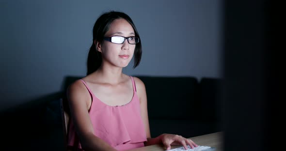 Young woman working on computer at night 