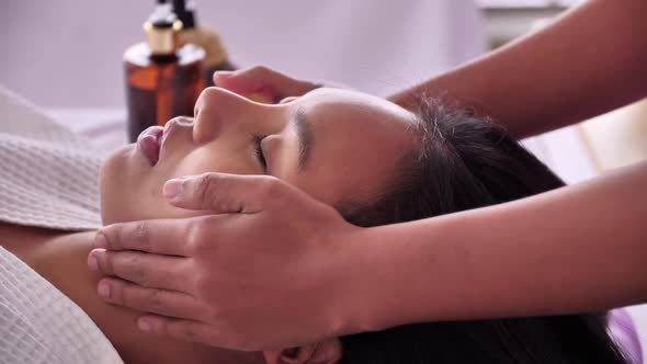 Young Asian woman getting facial massage in luxury spa salon