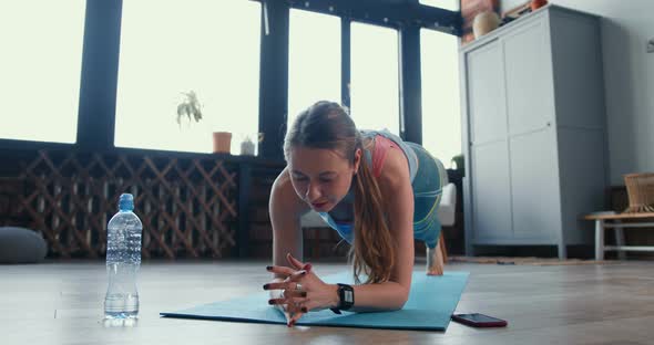 Beautiful Sporty Determined Blonde Woman Doing Elbow Plank Exercise at Home To Keep Healthy and Fit