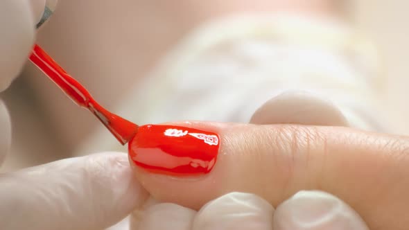 Close Up Manicurist Applying Red Varnish.