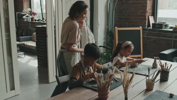 Woman Teaching Kids Sculpting Clay