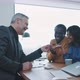 Young multi ethnic couple receiving car keys from agent sitting at a table - VideoHive Item for Sale