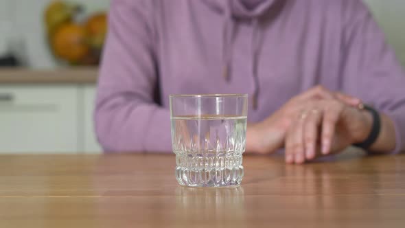 Young Woman at Home Drinks Water and Wants To Eat. Intermittent Fasting Concept