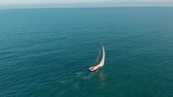 Aerial View. Sailing Yacht with White Sails in the Open Sea.