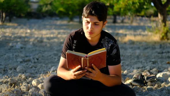 Man Reading Quran Outdoors
