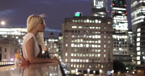 Pretty young woman standing on bridge enjoying view, London, UK