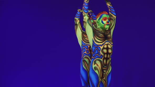 Twins In Fluorescent Luminous Suits And Painted Colorful Face.Body Art Glowing In Ultraviolet Light.