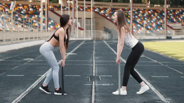 Sportswomen Doing Exercise with Resistance Fitness Rubber Band on Stadium