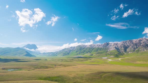 Time lapse: clouds moving in blue sky, sunny day on the mountains, view point over rocky mountain pe