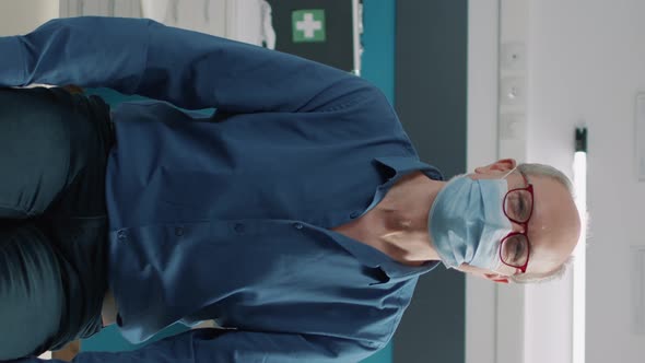 Vertical Video Portrait of Senior Man with Face Mask Attending Recovery Examination