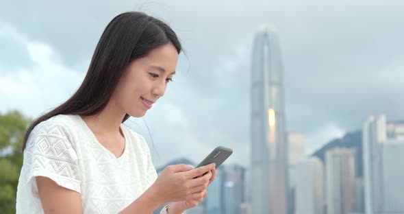 Woman look at smart phone in city