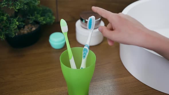 Child's Hand Which Doing Choice Between Two Toothbrushes Before Start to Clean Teeth