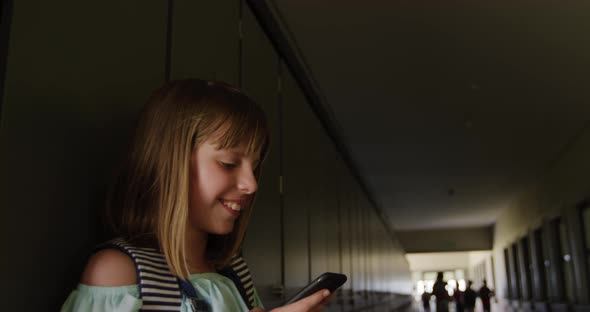 Girl using smartphone in the school corridor