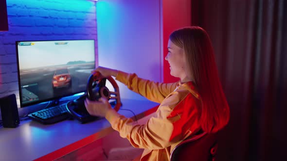 Girl playing car racing. Young girl playing video games at home