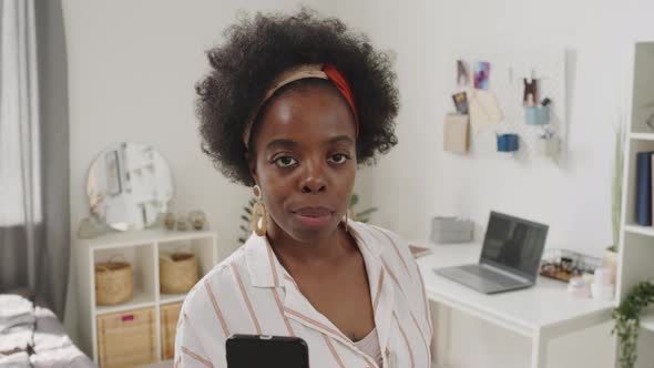 Portrait of African American Woman with Smartphone at Home