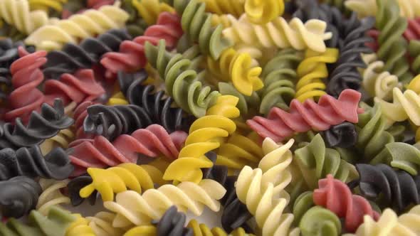 Colorful uncooked fusilli pasta. Falling a multi colored macaroni