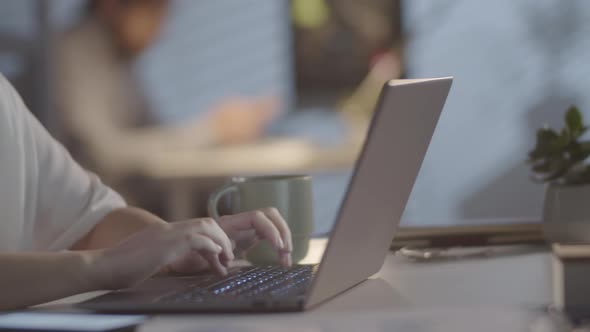 Businesswoman Typing on Laptop in Office