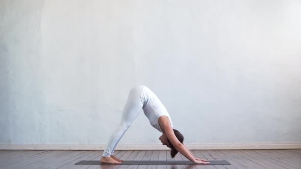 Young and fit woman practicing yoga indoor in the class.