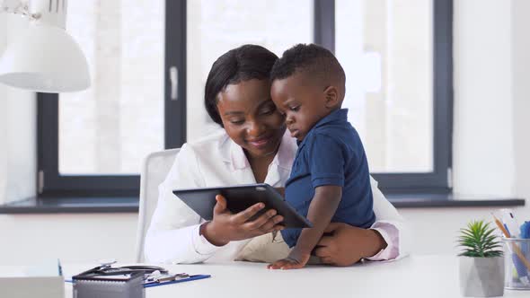 Doctor Showing Tablet Pc To Baby Patient at Clinic