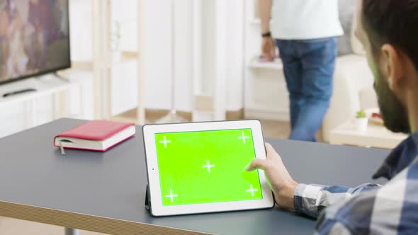 Male Working on Green Screen Digital Tablet PC in Beautiful and Well Lit Apartment