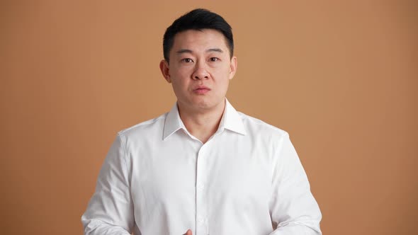 Happy Asian man wearing white shirt agree with something and showing thumb up gesture