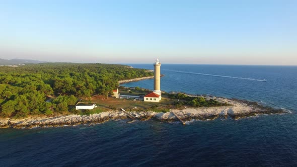 Flying over lighthouse, Croatia with a motorboat passing by