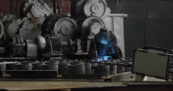 A Professional Welder Makes Steel Structures at the Factory