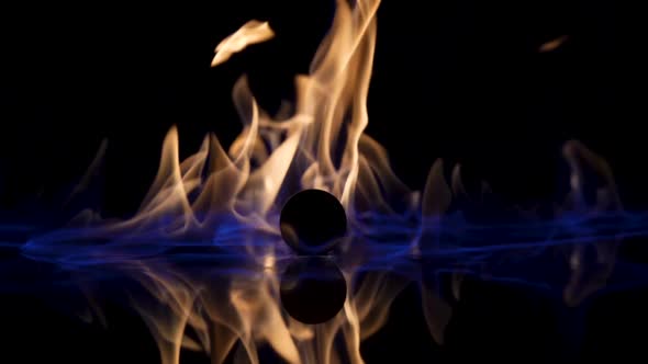 On a Black Reflective Background the Fire Ignites and Burns in Slow Motion