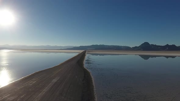 A drone shot flying over the Bonneville Salt Flats shows the Salt Flats causeway dividing the floode